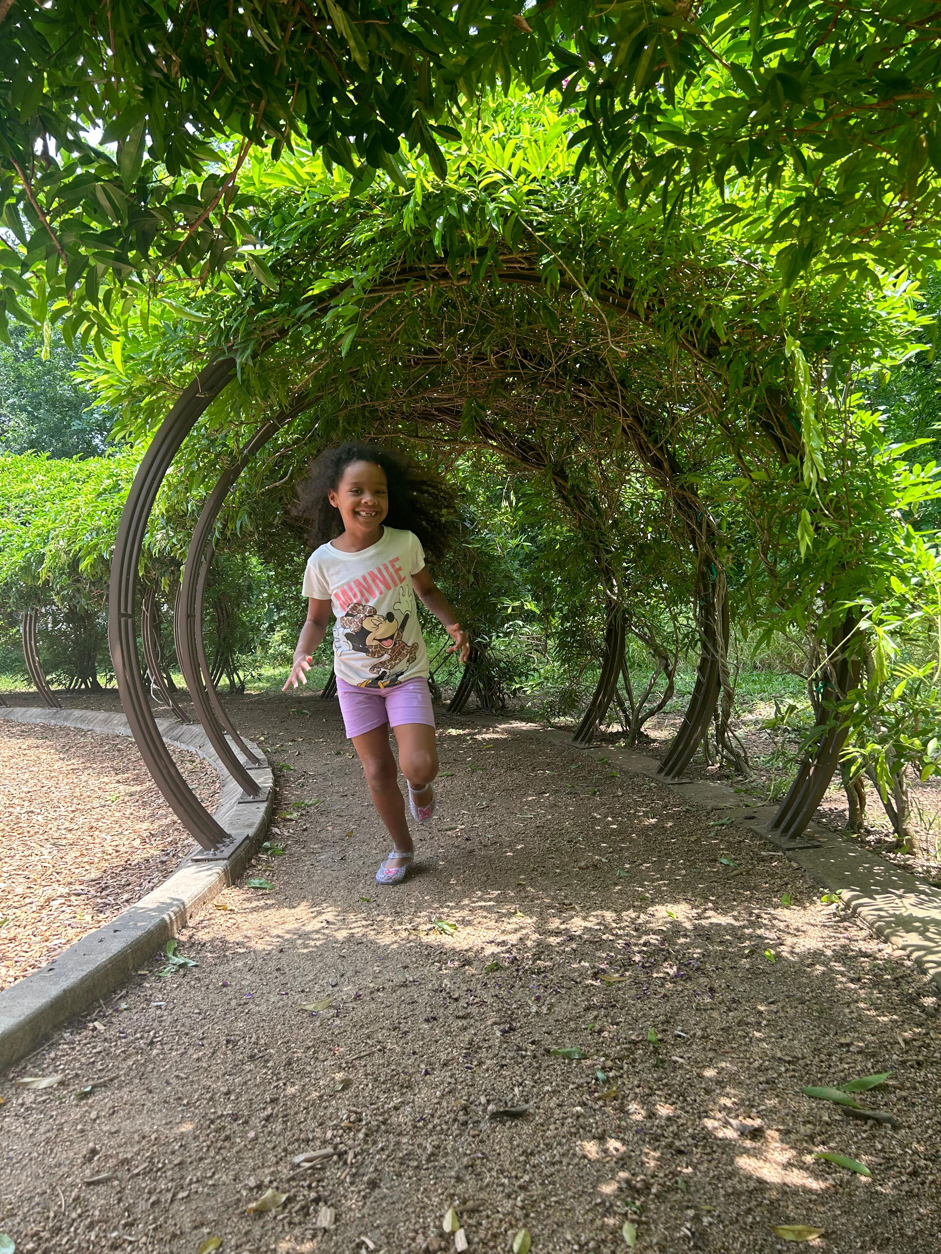 Young girl running through path with greenery Sienna master-planned community Fort Bend TX